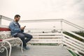 Happy guy is sitting on cute terrace outdoors