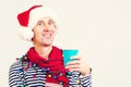 Smiling man in Santa Claus hat holding a paper cup of coffee. Christmas holidays. Christmas sales and discounts