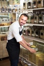 Seller with cereals sold by weight in shop. Royalty Free Stock Photo