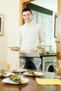 Smiling man serving cooked fish