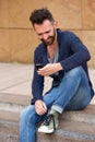 Smiling man on sidewalk using mobile phone Royalty Free Stock Photo