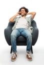 smiling man sitting in chair calling on smartphone Royalty Free Stock Photo