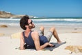 Smiling man sitting on secluded beach