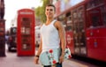 Smiling man with skateboard on london city street Royalty Free Stock Photo