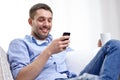 Smiling man with smartphone at home Royalty Free Stock Photo