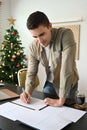 Man standing in home office and checking reports on wooden table. Royalty Free Stock Photo