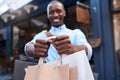 Smiling man standing outside carrying a load of shopping bags Royalty Free Stock Photo