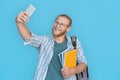 Smiling man student blogger hold phone record vlog isolated on blue background.