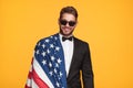 Smiling man in suit posing with flag