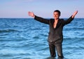 Smiling man in suit stands in sea