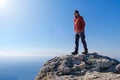 Smiling man in sunglasses standing at the peak of rock mountain