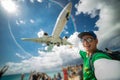 Smiling man taking selfie with airplane with beach, sea and lots tourists on background. Maho beach. Happy vacation and