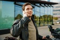 Smiling man talking on cellphone while standing with bicycle outside Royalty Free Stock Photo