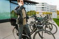 Smiling man talking on cellphone while standing with bicycle outside Royalty Free Stock Photo