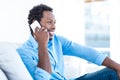 Smiling man talking over phone while sitting Royalty Free Stock Photo