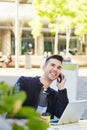 Smiling man on telephone call at cafe with laptop Royalty Free Stock Photo