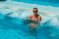 Smiling man tourist relaxing in pool jacuzzi outdoor at spa resort enjoying luxury life. Success, healthy lifestyle, body care con Royalty Free Stock Photo