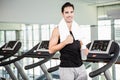 Smiling man on treadmill holding bottle of water Royalty Free Stock Photo