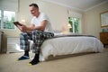 Man using digital tablet on bed in bedroom Royalty Free Stock Photo