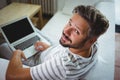 Smiling man using his laptop in living room Royalty Free Stock Photo