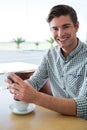Smiling man using his mobile phone in coffee shop Royalty Free Stock Photo