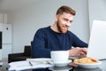 Smiling man using laptop computer at home Royalty Free Stock Photo