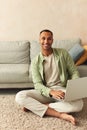 Smiling Man Using Laptop At Home. Young Guy Holding Computer, Sitting At Floor Royalty Free Stock Photo