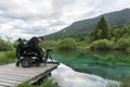 Man on wheelchair using mirrorless camera near the lake in nature