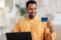 Smiling man using pc and credit card at home Royalty Free Stock Photo