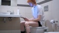 Smiling Man Using Tablet in Bathroom, Commode Royalty Free Stock Photo