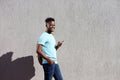 Smiling man walking with bag and mobile phone Royalty Free Stock Photo