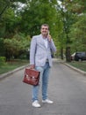 Smiling man walking on a blurred park background. A business employee talking on a phone. Financial stability concept. Royalty Free Stock Photo