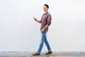 Smiling man walking and listening to music on mobile phone Royalty Free Stock Photo