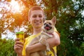 Smiling man walking at park and holding chihuahua dog and coffee to go Royalty Free Stock Photo