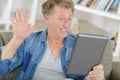smiling man waving at tablet Royalty Free Stock Photo