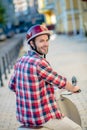 Smiling man wearing a plaid hirt and a helmet