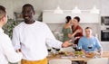 Smiling man welcoming friend to dinner party with handshake Royalty Free Stock Photo