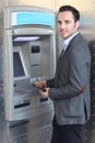 Smiling man withdrawing money at ATM