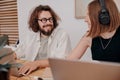 Smiling man and woman freelancers talking during working day in modern coworking