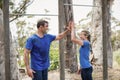 Smiling man and woman giving high five during obstacle course Royalty Free Stock Photo