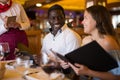 Positive young couple making order at restaurant Royalty Free Stock Photo