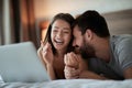 Smiling man and woman at home surfing the net in bed Royalty Free Stock Photo