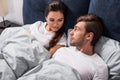 Smiling man and woman lying in bed