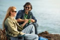 Smiling Man And Woman Relaxing Together On Rocks At Ocean Shore Royalty Free Stock Photo