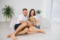 Smiling man and woman sitting on floor at home with their pet dog. Portrait of happy dog loving family with their pet dog Royalty Free Stock Photo