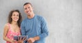 Smiling man and woman using tablet PC against wall Royalty Free Stock Photo