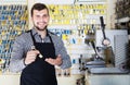 Smiling man worker demonstrating key in workshop Royalty Free Stock Photo