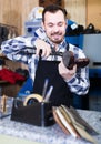 Smiling man worker working at restoring boots Royalty Free Stock Photo