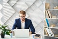 Smiling man working at desktop with joy