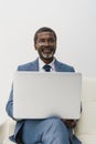 smiling African american man working with a laptop and looking